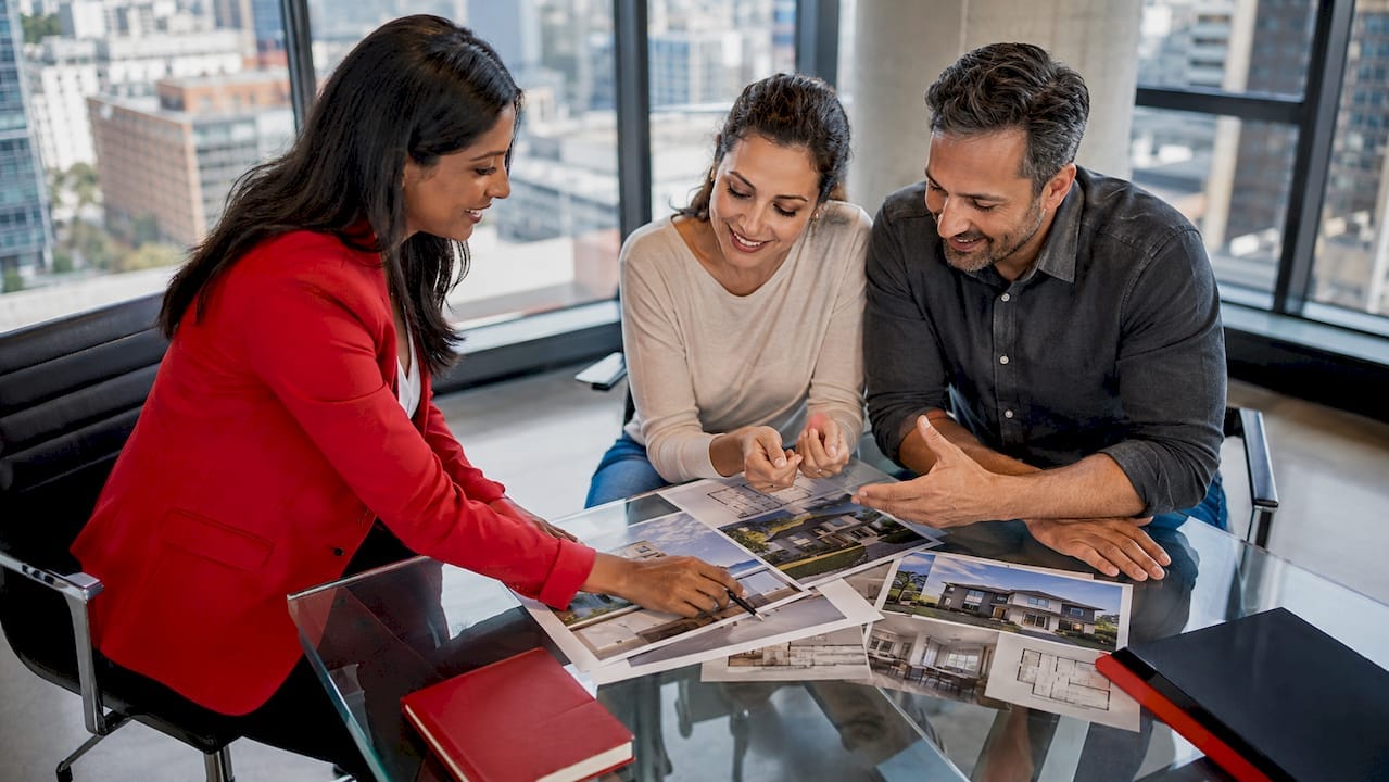 RE/MAX agent consulting active home buyers at kitchen table