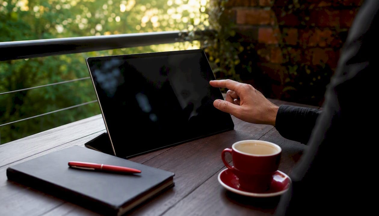 Tablet on desk with finger hovering