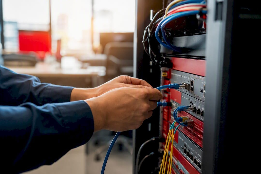 Hands connecting cable to server