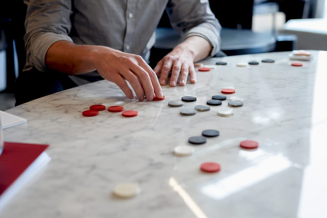 Hands adjusting tokens symbolizing AI bidding optimization